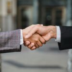 A close-up of two businesspeople shaking hands, symbolizing cooperation and partnership.